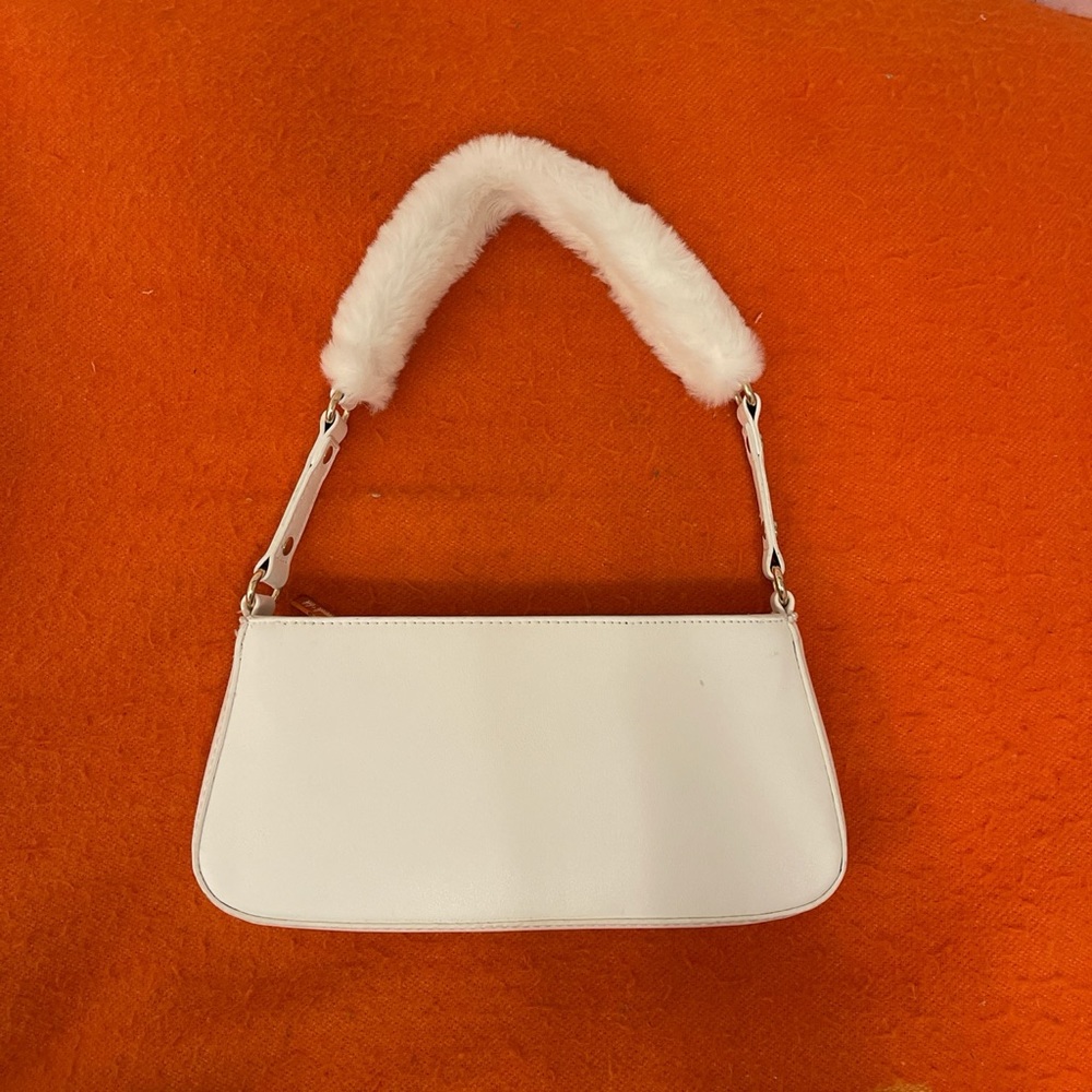White baguette bag with fur detailing at the top. Subtle gold hardware